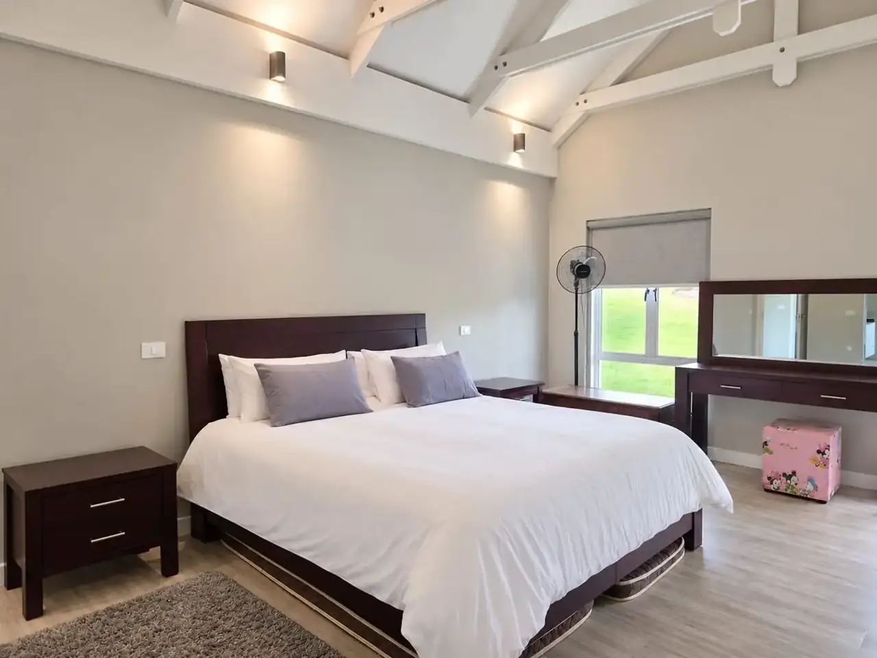 Moxie House — King bedroom beneath white ceiling beams