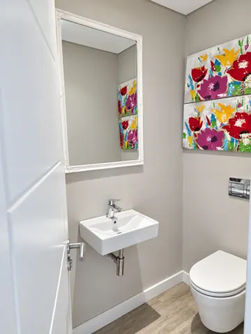 Moxie House — Guest bathroom with floral artwork
