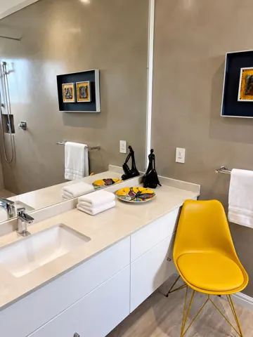 Moxie House — Bathroom vanity with yellow accent chair